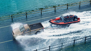 Brauner Ford Ranger mit angehängtem Boot auf einer nassen Fahrbahn